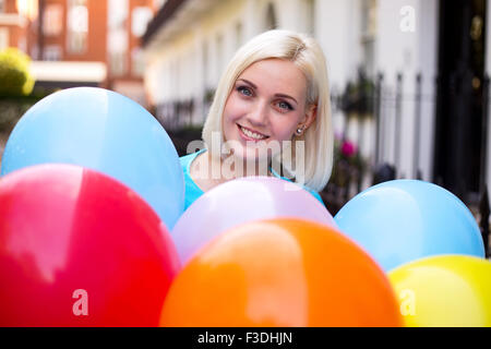 Giovane donna palloncini di contenimento Foto Stock