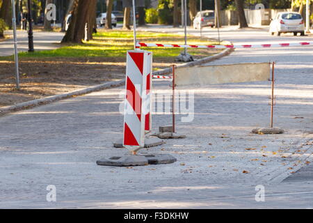 Cartello stradale informare circa il pericolo durante la riparazione della pavimentazione, costruzione di strada su una strada di città Foto Stock