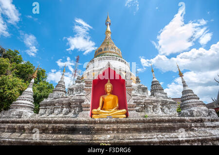 White chedi e golden statua del Buddha al Wat Buppharam, Chiang Mai Foto Stock