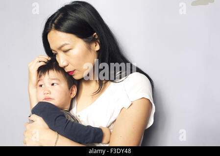 Madre consolante giovane figlio Foto Stock