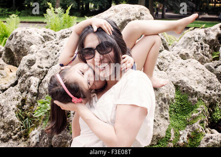 Ragazza abbracciando e baciando la madre Foto Stock