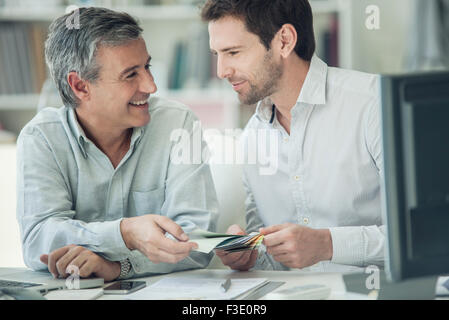 I colleghi guardando i campioni di colore insieme Foto Stock