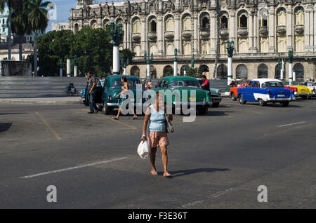 Una donna locale sta attraversa la strada con il suo shopping di fumare un sigaro cubano in Havana la capitale della Repubblica di Cuba Foto Stock