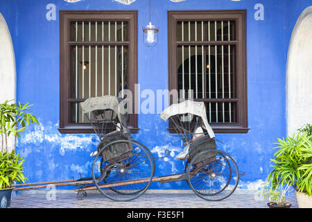 Georgetown, Malesia - 04 August, 2014: vecchi rickshaw triciclo vicino Fatt Tze Mansion o Residenza Blu Foto Stock