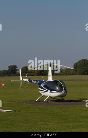 Elicottero parcheggiato su erba. Aeroporto di Wolverhampton. Regno Unito Foto Stock
