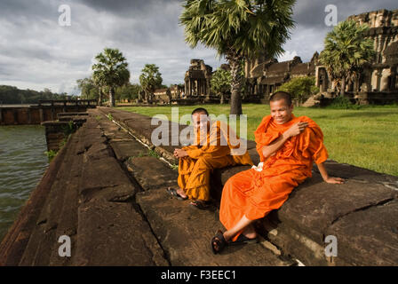 Due monaci buddisti all'esterno del tempio di Angkor Wat. Angkor Wat, la sua bellezza e il suo stato di conservazione è impareggiabile Foto Stock