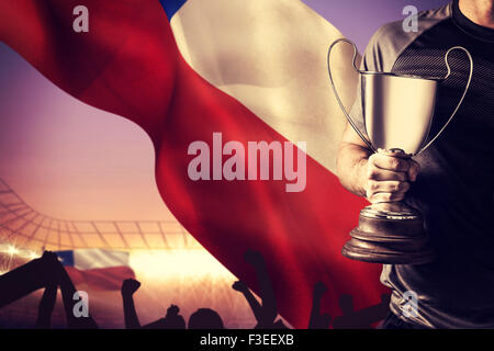 Immagine composita della sezione mediana di successo del giocatore di rugby trofeo holding e la sfera Foto Stock