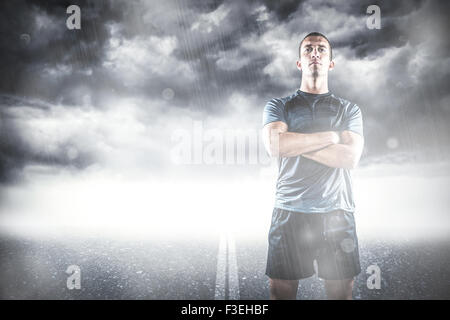 Immagine composita di piena lunghezza di fiduciosa giocatore di rugby con le braccia incrociate Foto Stock