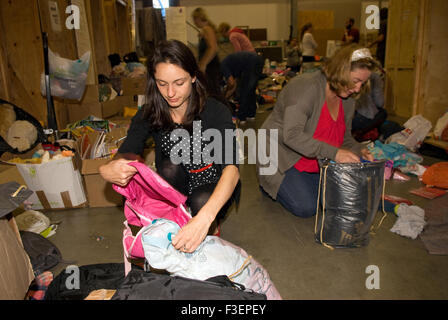 I volontari in una società di spedizione dal magazzino di imballare donati capi di abbigliamento e altri non deperibili per la spedizione... Foto Stock