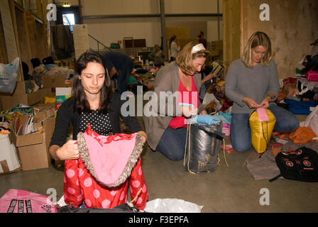 I volontari in una società di spedizione dal magazzino di imballare donati capi di abbigliamento e altri non deperibili per la spedizione... Foto Stock