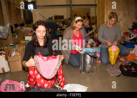 I volontari in una società di spedizione dal magazzino di imballare donati capi di abbigliamento e altri non deperibili per la spedizione... Foto Stock