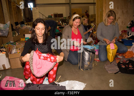 Volontari nel magazzino della compagnia di spedizione imballare gli articoli donati di abbigliamento e altri articoli per la spedizione in Grecia per aiutare i rifugiati siriani... Foto Stock