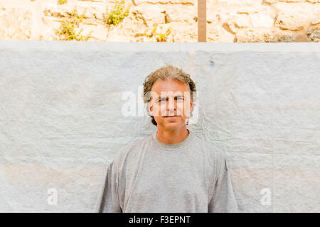 Uomo adulto in grigio t-shirt nella parte anteriore di un panno ondulato schermo Foto Stock