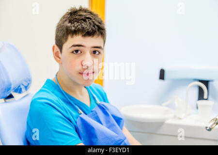 Ragazzo seduto sulla sedia del dentista e con calma in attesa che il medico dentista Foto Stock