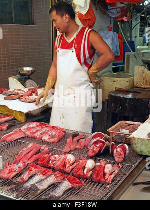 Pescivendolo cinese sul lavoro Preparazione del pesce per la vendita in un mercato di Hong Kong Foto Stock