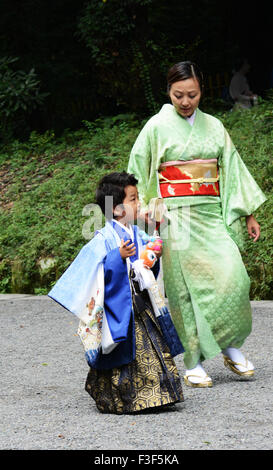 La madre e il Figlio suo vestito di kimono tradizionali per raggiungere a piedi il tempio di Meiji in Tokyo. Foto Stock