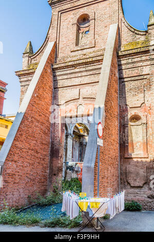 Vestiti appesi ad asciugare su una rastrelliera per essiccamento di fronte tra le rovine storiche in Italia Foto Stock