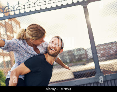 Amare giovane divertendosi, Donna sulla Le Mans indietro, Piggyback Foto Stock