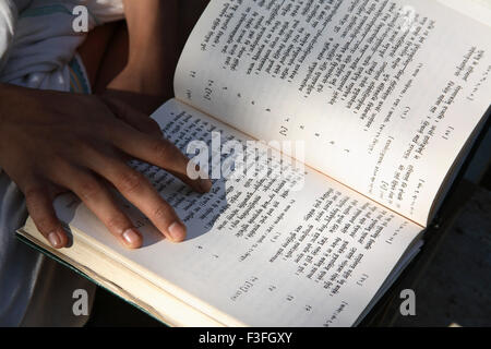 Giovane studente di studi religiosi imparare dal cuore Rugveda o Vedas studiando altre scritture religiose Foto Stock