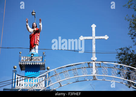 Statua di Gesù Cristo sollevando la sua mano sia per dare la benedizione con la croce sull'arco in acciaio del cancello principale chiesa Kerala Foto Stock