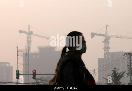 Pechino, Cina. Il 7 ottobre, 2015. Una donna che indossa una maschera passeggiate di haze a Pechino Capitale della Cina, il 7 ottobre 2015. Credito: Tao Ye/Xinhua/Alamy Live News Foto Stock