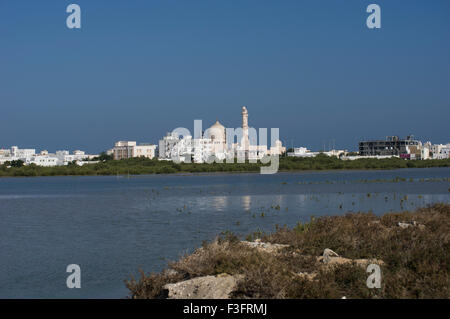 Vista di una moschea attraverso il lago in Sur nel Sultanato di Oman, una cassetta di sicurezza e accogliente golfo membro destinazione di vacanza Foto Stock