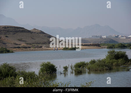 Vista sulle montagne di una collina attraverso il lago in Sur nel Sultanato di Oman, una cassetta di sicurezza e accogliente golfo membro destinazione di vacanza Foto Stock