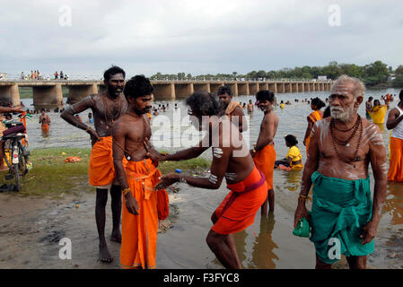 Pellegrini decorate con le sacre ceneri dopo il bagno nel fiume Tamiravaruni ; Tiruchendur ; Tamil Nadu ; India Foto Stock