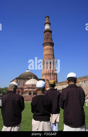 I bambini facendo Namaz Alai Darwaza Imam Zamin tomba Qutab Minar pietra arenaria rossa torre Indo arte musulmana Delhi Foto Stock