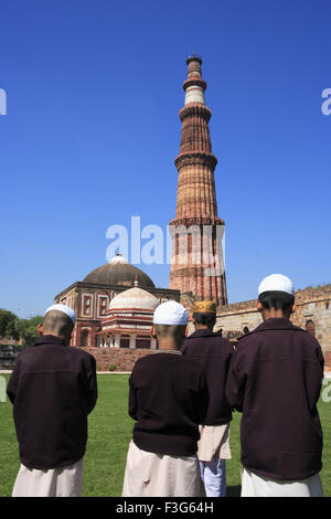 I bambini facendo Namaz Alai Darwaza Imam Zamin tomba Qutab Minar pietra arenaria rossa torre Indo arte musulmana Delhi Foto Stock