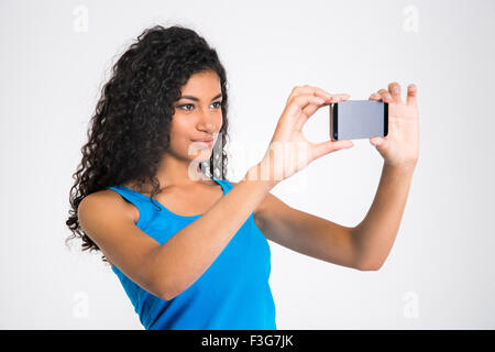 Ritratto di un grazioso afro american donna fare foto selfie isolato su uno sfondo bianco Foto Stock