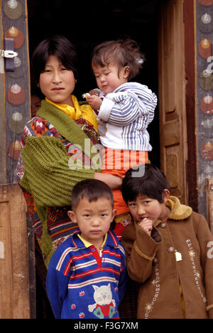 Madre e bambini in piedi nella parte anteriore del negozio a Paro e Royal Govt del Bhutan MR 07 12 Foto Stock