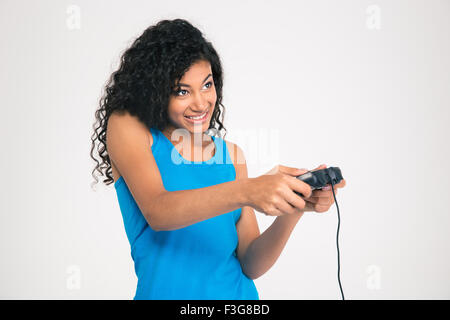 Ritratto di un felice afro american donna giocando nel video gioco con joystick isolato su uno sfondo bianco Foto Stock