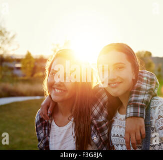 Due ragazze adolescenti al di fuori in una serata estiva in sun flare Foto Stock