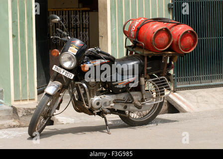 La consegna a domicilio di gas GPL cilindri su due ruote di Bajaj Kawasaki al villaggio Suchindram ; Tamil Nadu ; India Foto Stock