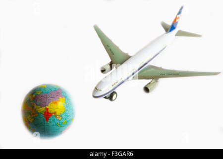 Aeroplano giocattolo Boeing 777 e globo su sfondo bianco Foto Stock