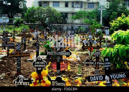 Commemorazione di tutti i defunti tombe decorate fiori candele accese cerimonia Chiesa Andrews Bombay Mumbai Maharashtra Foto Stock