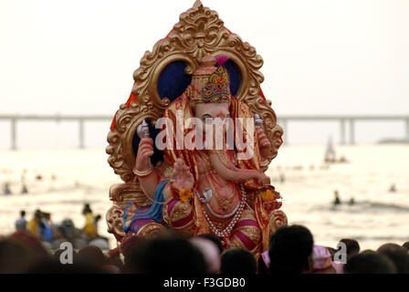 Immersione del idol del signore Ganesh ganpati seduto sul trono d'oro a Dadar beach Mumbai Bombay ; Maharashtra ; India Foto Stock