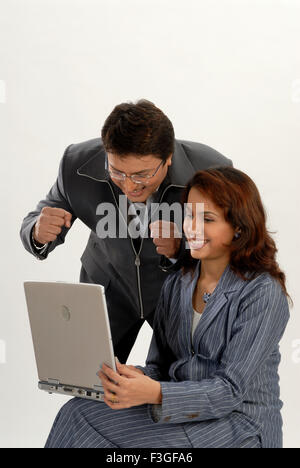 Uomo eccitato guardando il computer portatile donna che lavorano su sfondo bianco signor#682L&M Foto Stock