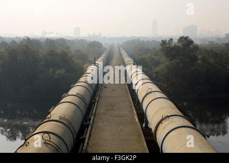 Tubi d'acqua per Mumbai Sud passa attraverso Dharavi drappeggiato in smog, Bombay, Mumbai, Maharashtra, India, Asia, India, Asia Foto Stock