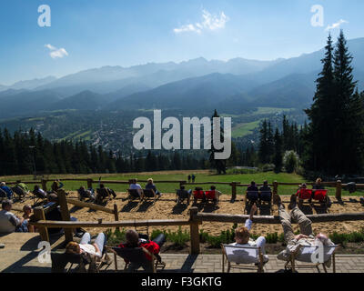 I turisti a prendere il sole in cima Gubalowka vista collina dei Monti Tatra ZAKOPANE Poland popolare località turistica nel sud della Polonia sulla bella giornata autunnale Foto Stock