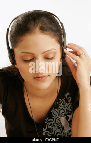 Maharashtrian ragazza adolescente attentamente ascoltare la musica tramite auricolari signor#686M Foto Stock