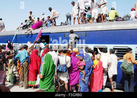 Persone trascinando i bambini e le donne cercando di salire sul tetto del treno sulla stazione ferroviaria ; jodhpur ; rajasthan ; india - shi 141783 Foto Stock