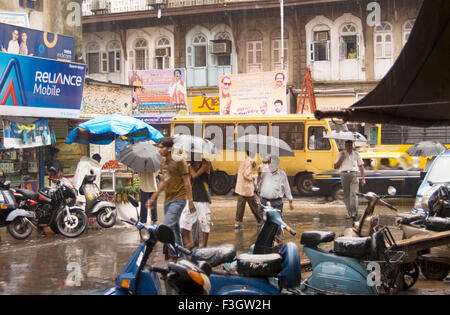 Il periodo del monsone persone con ombrellone sulla strada di Bombay Mumbai ; Maharashtra ; India Foto Stock