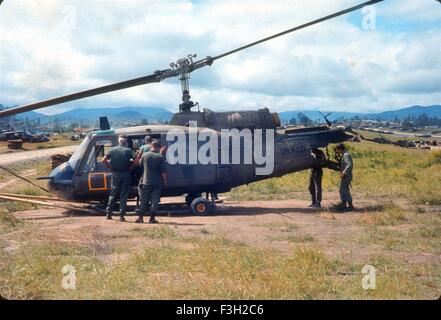 Noi soldati dell esercito guardare Bravo truppa, 1° Stormo, 9 Cavalleria, 1a divisione di cavalleria gunship elicottero schiantato. Un Khe Vietnam 1966. Foto Stock