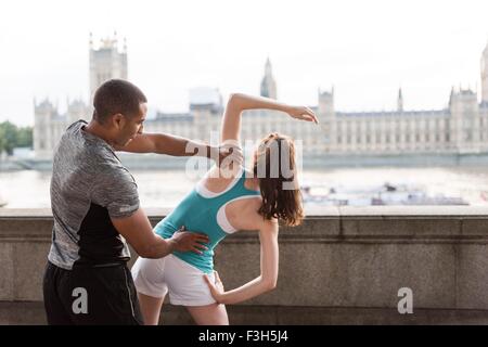 Voce maschile e femminile in fase di riscaldamento sulla Southbank, London, Regno Unito Foto Stock