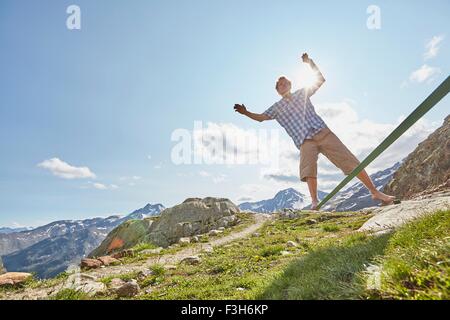Giovane uomo bilanciamento sulla slackline in Val Senales ghiacciaio della Val Senales, Alto Adige, Italia Foto Stock