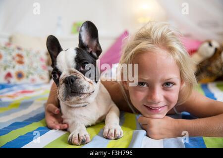 Ritratto di ragazza e la cute cane sdraiato sul letto Foto Stock