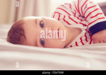 Bambino giacente sul letto Foto Stock