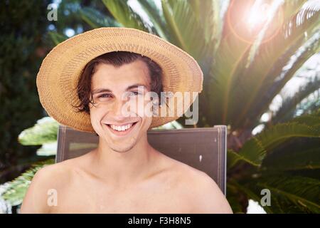 Ritratto di giovane sorridente uomo che indossa cappello Foto Stock